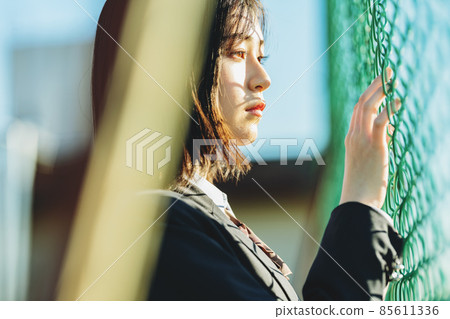 High school girl standing in front of the fence 85611336