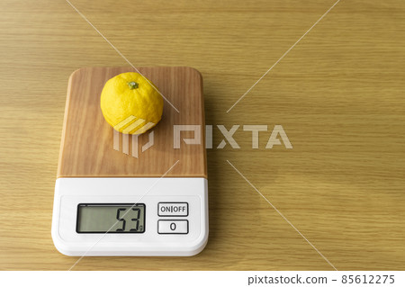 在數字廚房秤上稱量柚子的圖像 在數字廚房秤上稱量柚子的圖像 85612275