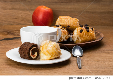 Delicious coffee break with various dessert in white ceramic dish with a cup of coffee and red ripe apple. Delicious coffee break with various dessert in white ceramic dish with a cup of coffee and red ripe apple. 85612957