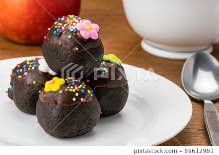 Pile of delicious homemade Choc Balls or Chocolate Balls in white ceramic dish. 85612961