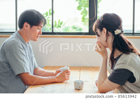 Men and women drinking coffee in a fashionable space (worried) 85613942