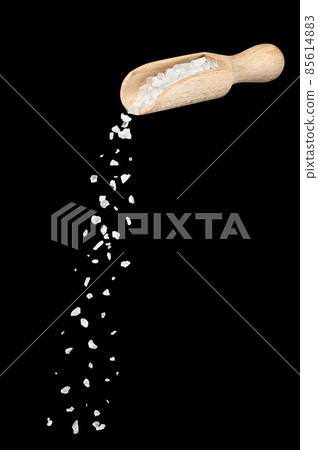 white sea salt falling from wooden spoon isolated 85614883