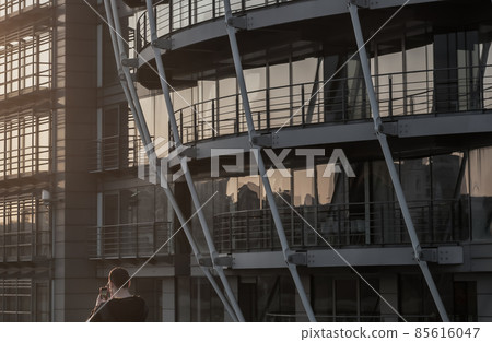 Modern building with repeating structure and reflected sky and clouds. 85616047
