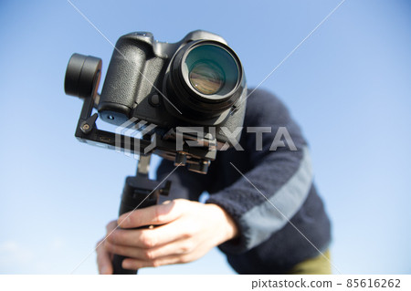 A cameraman who shoots images using a gimbal A cameraman who shoots images using a gimbal 85616262