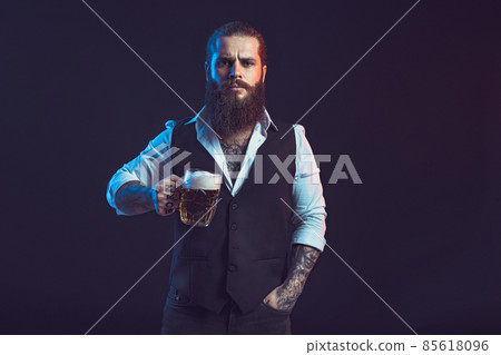Half length of Bearded man who holds mug of beer looking at camera over black background Half length of Bearded man who holds mug of beer looking at camera over black background 85618096