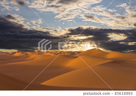 Sunset over the sand dunes in the desert. Arid landscape of the Sahara desert. 85618993