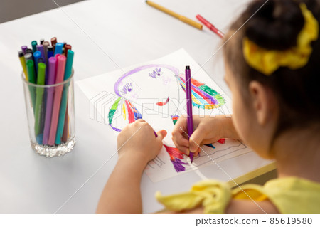 Little brunette girl drawing with colored markers. Little brunette girl drawing with colored markers. 85619580