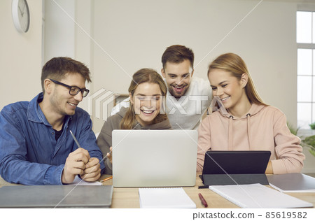 Group of happy creative university students sitting at table, looking at modern laptop computer, talking, discussing business ideas, making web marketing presentation together. Education concept Group of happy creative university students sitting at table, looking at modern laptop computer, talking, discussing business ideas, making web marketing presentation together. Education concept 85619582