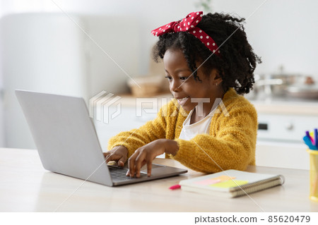 Distance Learning. Cute Little Black Girl Study With Laptop At Home 85620479