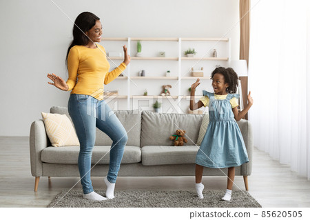 Cheerful Black Mom And Little Daughter Dancing Together At Home 85620505