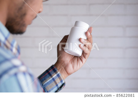 young man hand holding medicine pill container  85622081