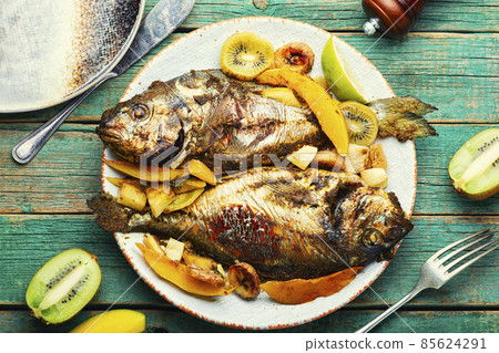 Baked fish with pineapple, mango and kiwi. 85624291
