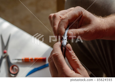 A man is repairing a smartphone. A man is repairing a smartphone. 85624593