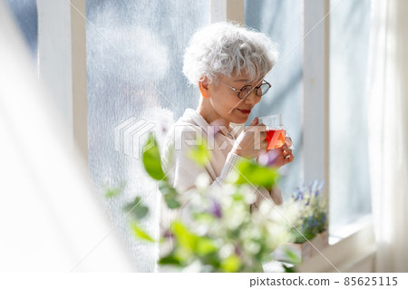放鬆與飲料的資深婦女 85625115