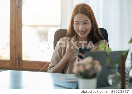 portrait of cheerful asian woman are happy while using smartphone for video call. business concept portrait of cheerful asian woman are happy while using smartphone for video call. business concept 85625877