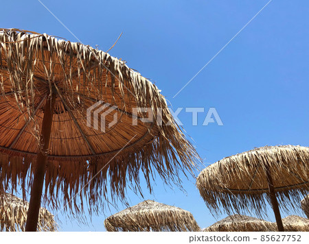 straw umbrellas against blue sky in summer straw umbrellas against blue sky in summer 85627752