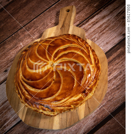Galette des rois on wooden table, Traditional Epiphany cake in France Galette des rois on wooden table, Traditional Epiphany cake in France 85627808