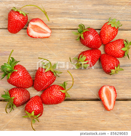 Red strawberries on a wooden table . 85629083
