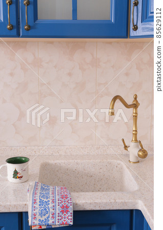 blue wooden kitchen interior fragment with sink and tape closeup photo 85629112