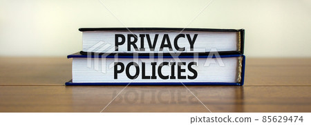Privacy policies symbol. Concept words 'Privacy policies' on books on a wooden table. Beautiful white background. Business and privacy policies concept, copy space. 85629474