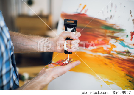 Talented man applying various paints on hand 85629907