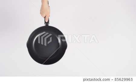 Cleaning Electric non stick pan. Hand on white background cleaning the non stick pan with handy dish washing sponge which yellow color on the soft side and green on hard side for hygiene after cook. Cleaning Electric non stick pan. Hand on white background cleaning the non stick pan with handy dish washing sponge which yellow color on the soft side and green on hard side for hygiene after cook. 85629963
