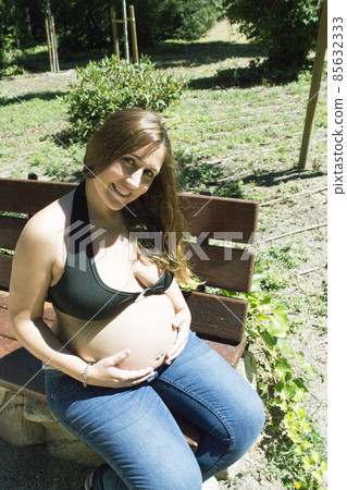 Seven month pregnant woman in a park Seven month pregnant woman in a park 85632333