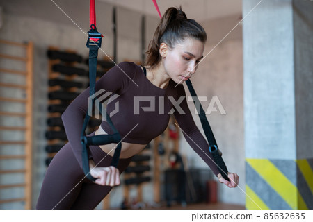 Fit woman doing push-up exercise with trx Fit woman doing push-up exercise with trx 85632635
