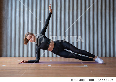 Young woman doing a side plank exercise Young woman doing a side plank exercise 85632706