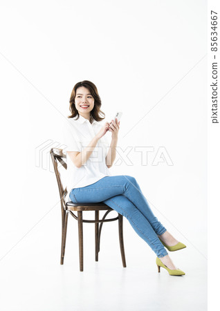 Young female smartphone search white background sit Young female smartphone search white background sit 85634667