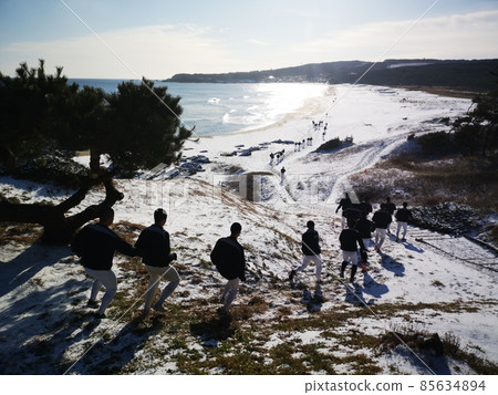 下降在一個多雪的海灘的高中棒球運動員 下降在一個多雪的海灘的高中棒球運動員 85634894