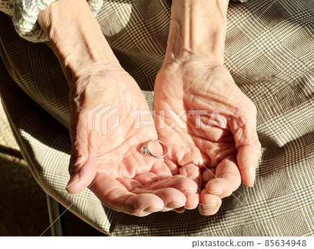 An elderly woman who puts a wedding ring on the palms of both hands 85634948