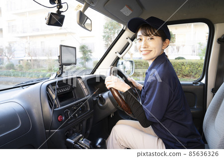 A courier woman smiling in the car A courier woman smiling in the car 85636326