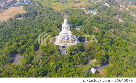 Aerial view of Wat Nong Hoi Park, white buddha pagoda stupa in a temple Park, Ratchaburi, Thailand with green mountain hills and forest trees. Thai buddhist temple architecture. Tourist attraction. Aerial view of Wat Nong Hoi Park, white buddha pagoda stupa in a temple Park, Ratchaburi, Thailand with green mountain hills and forest trees. Thai buddhist temple architecture. Tourist attraction. 85640079