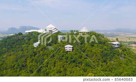 Aerial view of Thai village, hotel resort on green mountain hills with forest trees, Ratchaburi, Thailand. Nature landscape in travel trip and vacation. Aerial view of Thai village, hotel resort on green mountain hills with forest trees, Ratchaburi, Thailand. Nature landscape in travel trip and vacation. 85640083