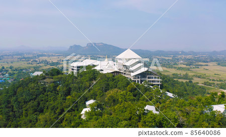 Aerial view of Thai village, hotel resort on green mountain hills with forest trees, Ratchaburi, Thailand. Nature landscape in travel trip and vacation. Aerial view of Thai village, hotel resort on green mountain hills with forest trees, Ratchaburi, Thailand. Nature landscape in travel trip and vacation. 85640086