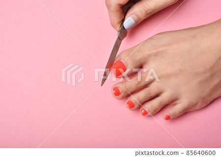 Woman feet on pink background, Red nail pedicure, Beauty salon concept. 85640600