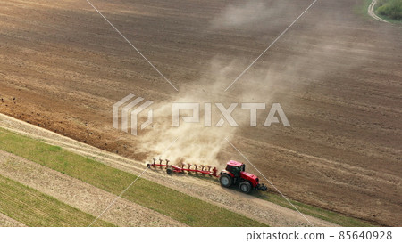 4K Aerial Flat View Tractor Plowing Field In Spring Season. Beginning Of Agricultural Spring Season. Cultivator Pulled By A Tractor In Countryside Rural Field Landscape. Birds In Flock Following For 4K Aerial Flat View Tractor Plowing Field In Spring Season. Beginning Of Agricultural Spring Season. Cultivator Pulled By A Tractor In Countryside Rural Field Landscape. Birds In Flock Following For 85640928