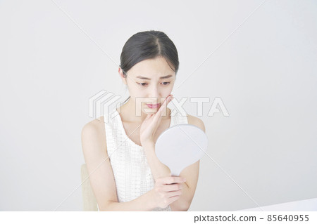 Woman looking at mirror Woman looking at mirror 85640955