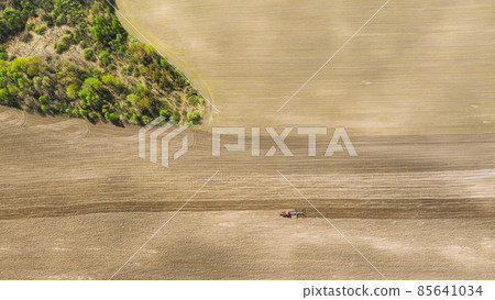 Tractor Plowing Field In Spring. Beginning Of Agricultural Season. Cultivator Pulled By A Tractor In Countryside Rural Field. Countryside Field Landscape. Aerial View. dronelapse, 4K Tractor Plowing Field In Spring. Beginning Of Agricultural Season. Cultivator Pulled By A Tractor In Countryside Rural Field. Countryside Field Landscape. Aerial View. dronelapse, 4K 85641034