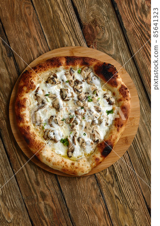 Mushroom pizza, pizza with addition of edible forest mushrooms porcini mushrooms, chanterelle and mozzarella cheese and herbs on a wooden rustic table Mushroom pizza, pizza with addition of edible forest mushrooms porcini mushrooms, chanterelle and mozzarella cheese and herbs on a wooden rustic table 85641323