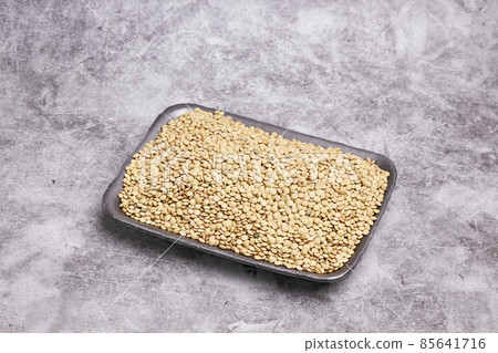 Dried green lentils on a black tray on a gray stone background. Healthy food concept Dried green lentils on a black tray on a gray stone background. Healthy food concept 85641716