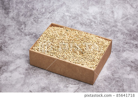 Cardboard box with dried green lentils on a gray stone background. Vegan food concept Cardboard box with dried green lentils on a gray stone background. Vegan food concept 85641718