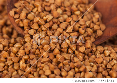Group of buckwheat groats in a wooden spoon, healthy food 85641833