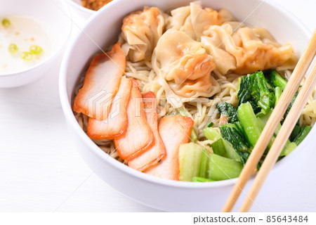 Noodles soup with wonton dumpling and grilled red pork in bowl on white background, Asian food 85643484