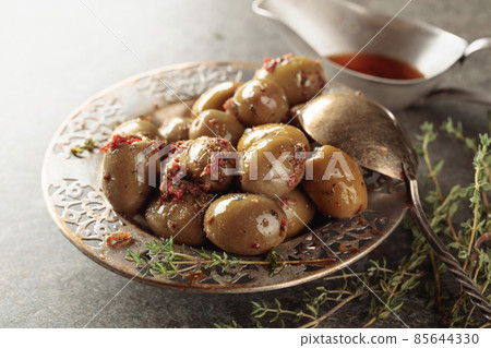 Bowl with olives and thyme twigs on a stone table. 85644330