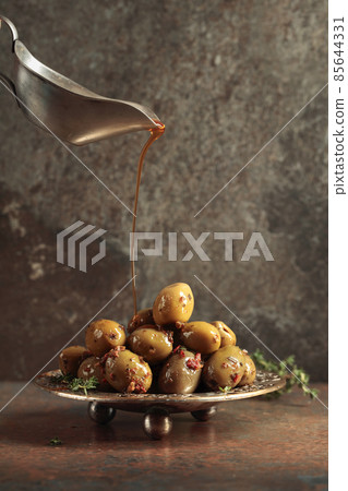 Spicy green olives are poured with olive oil with spices. 85644331