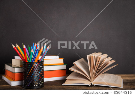 Stack of books and stationery on the background of the school board Stack of books and stationery on the background of the school board 85644516