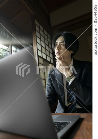 在日式房間裡做遠程工作的男人 85644958