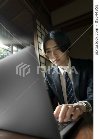 A man doing remote work in a Japanese-style room 85644959